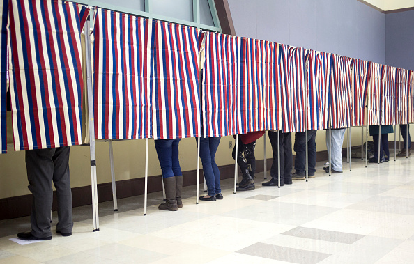 Voters Fill Out Their Ballots In The Patriotic Voting Booths At A Picture Id621812982