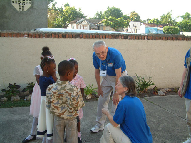 Tom and daughter Ann talking with students at a school in Jamaica.