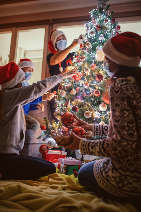 People Wearing Masks Around Christmas Tree