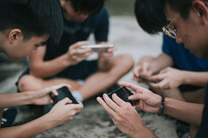 people playing games on smart phones while sitting in circle