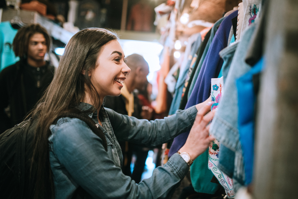 Young Adults Shop For Clothes At Thrift Store