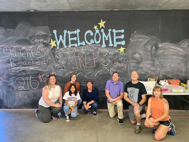 Quirk's Staff In Front Of Mref Chalkboard Wall
