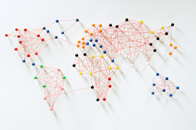Radius Global Market Research: World map using thumb tacks and string.