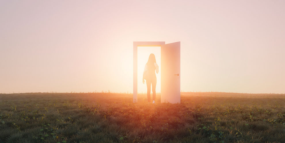A person walking though a door in a field.