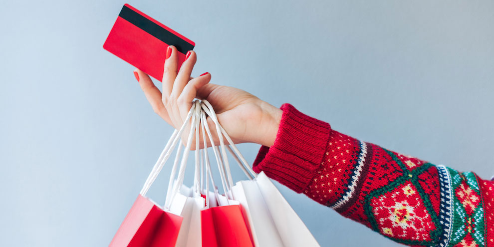 How Consumers Are Spending This Holiday Season Person Holding Bags And Card