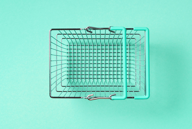 A teal background with a metal and teal shopping basket.
