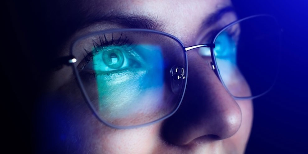 A person wearing glasses looking at a screen.