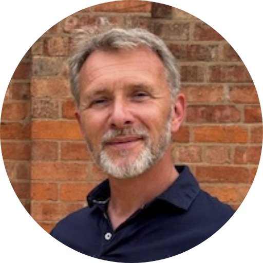 James Wycherley’s headshot with a brick wall in the background.