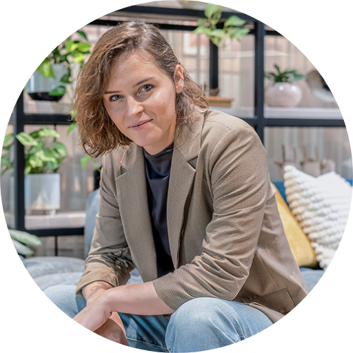 Betsy Shaak’s circular headshot with a room in the background.