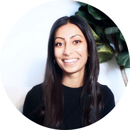 Ria Shah’s circular headshot on a white background with a plant semi-blurred in the top right.